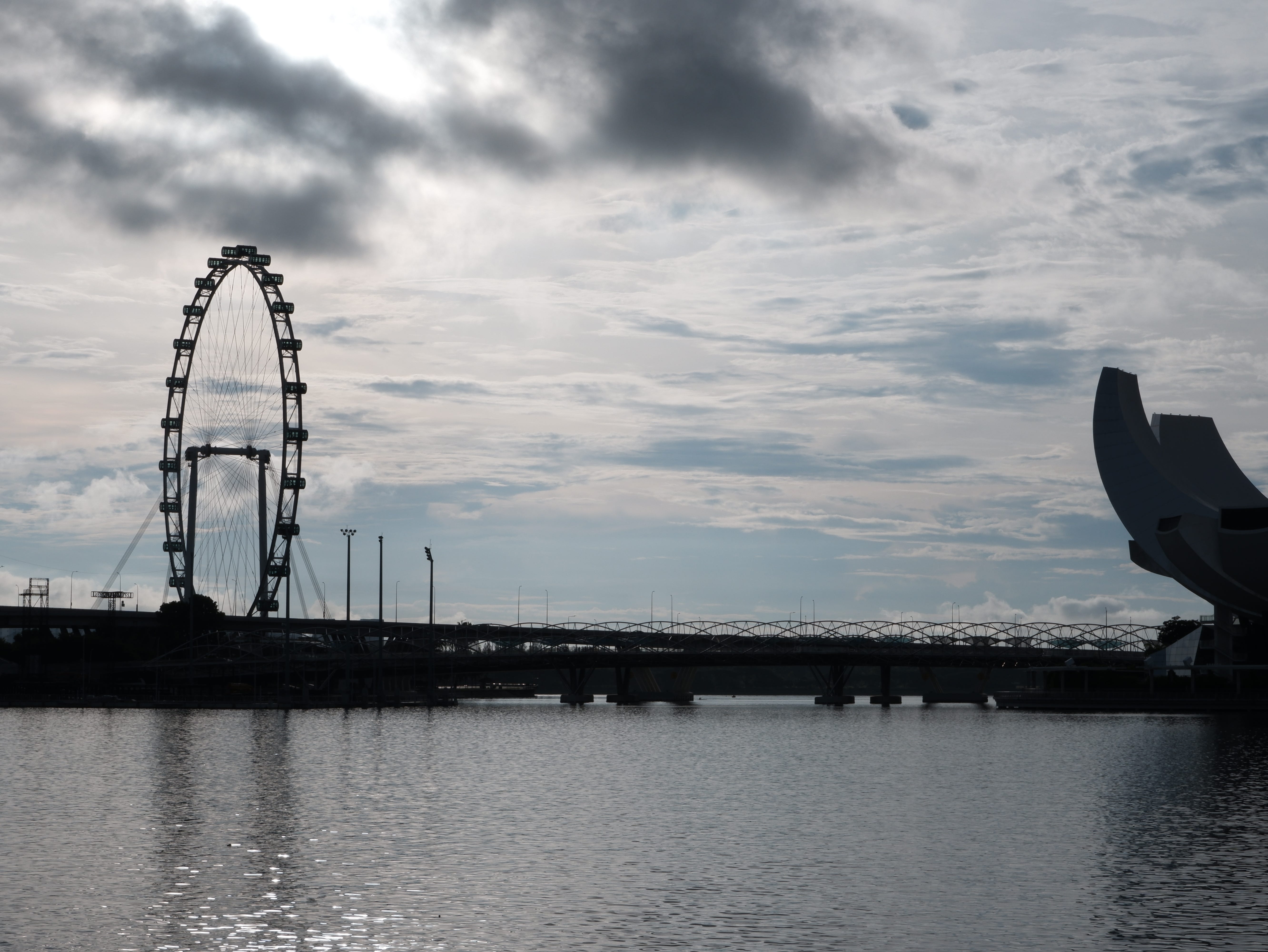 The Singapore Flyer and the ArtScience Museum, silhouetted against the morning sky.