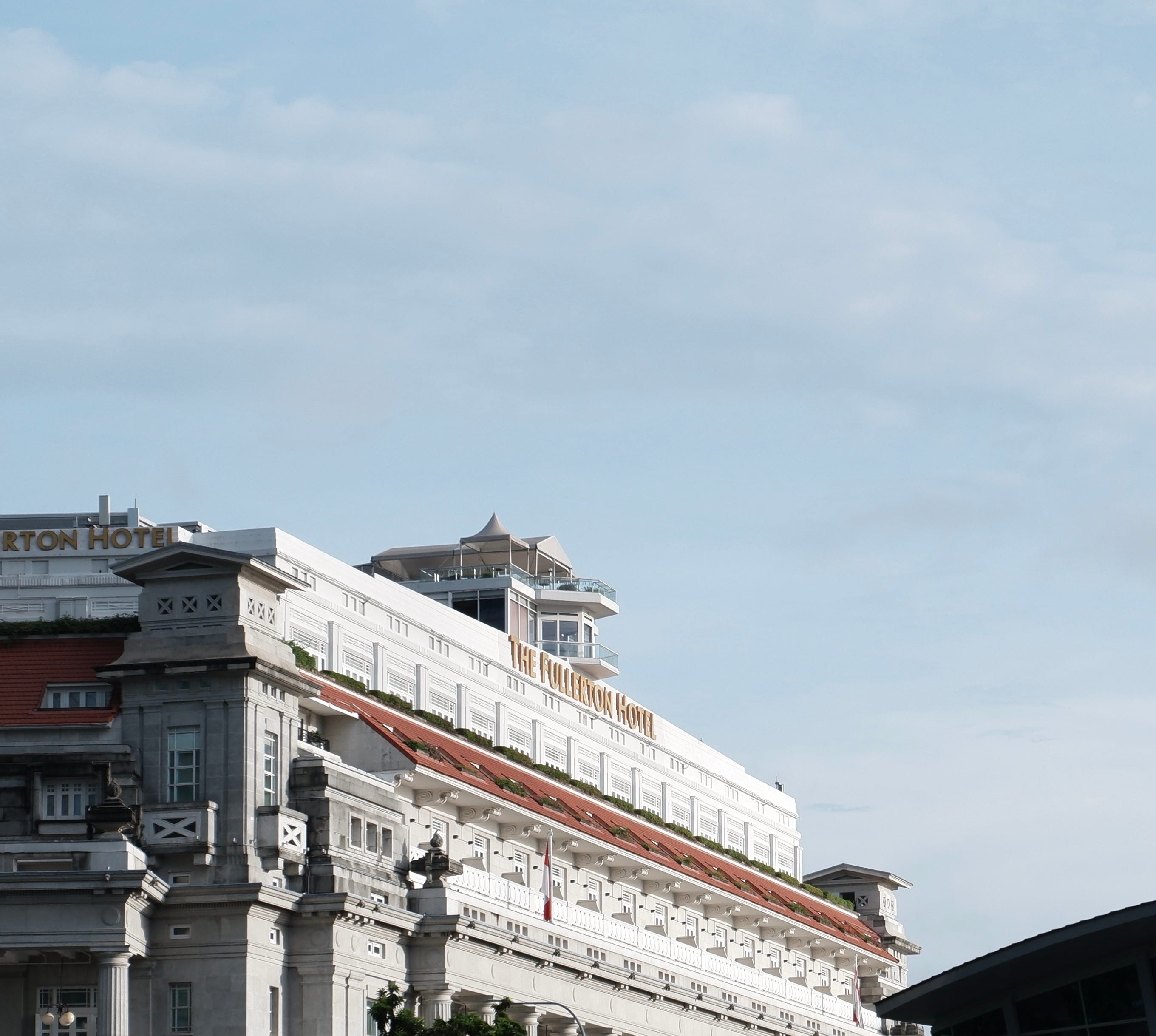 The marble facade of the Fullerton Hotel faces the rising sun.