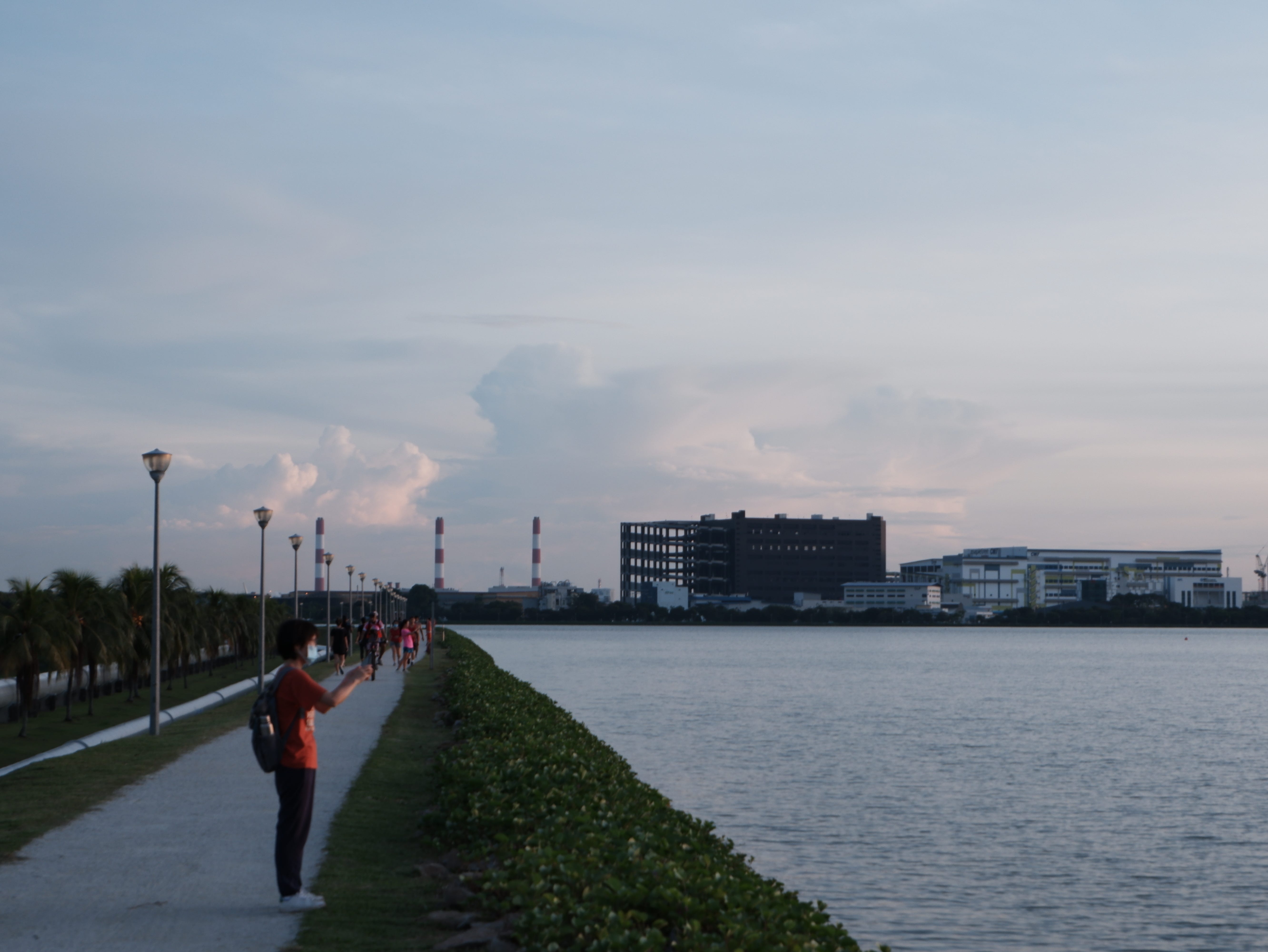 People stop to admire the setting sun and take photos.