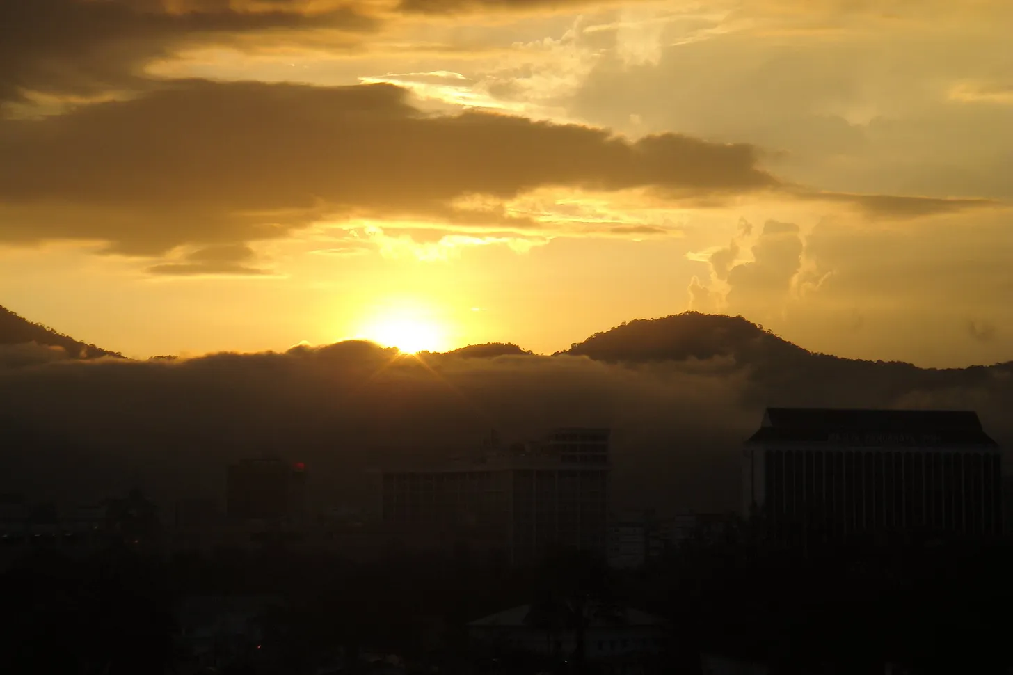 Late sunlight emerging beneath dark clouds.